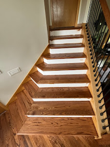 A wooden stairway in a home, featuring polished hardwood floors that enhance the interior's elegance and warmth.