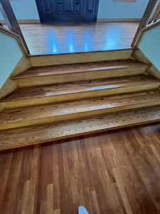 A wooden stairway in a home, featuring polished hardwood floors that enhance the interior's elegance and warmth.