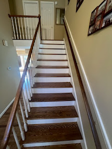 A wooden stairway in a home, featuring polished hardwood floors that enhance the interior's elegance and warmth.